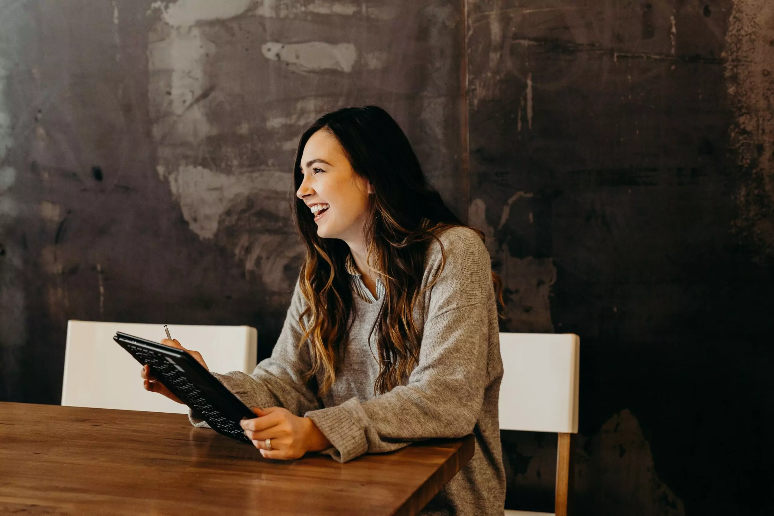 women holding an ipad and laughing