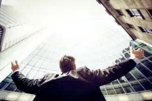 man next to a building holding his arms out
